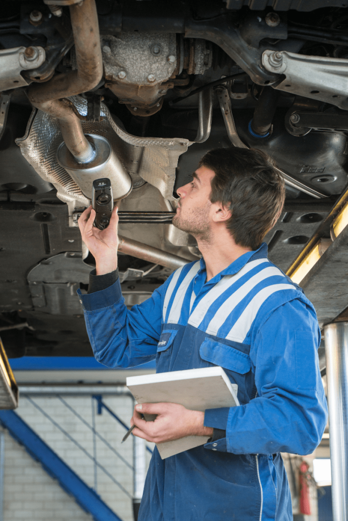 Mechanic looking underneath a vehicle during its MOT test